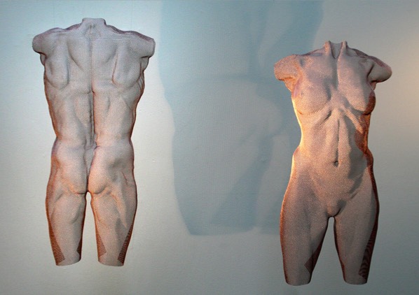 Rose-gold body sculpture of a male and female torso with cross lighting
