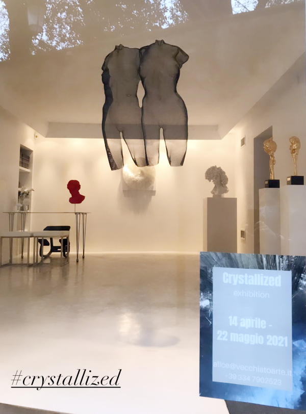 Art gallery window with suspended torso sculptures in Italy