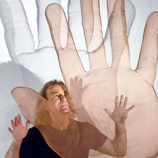 A hand sculpture is floating in front of artist David Begbie
