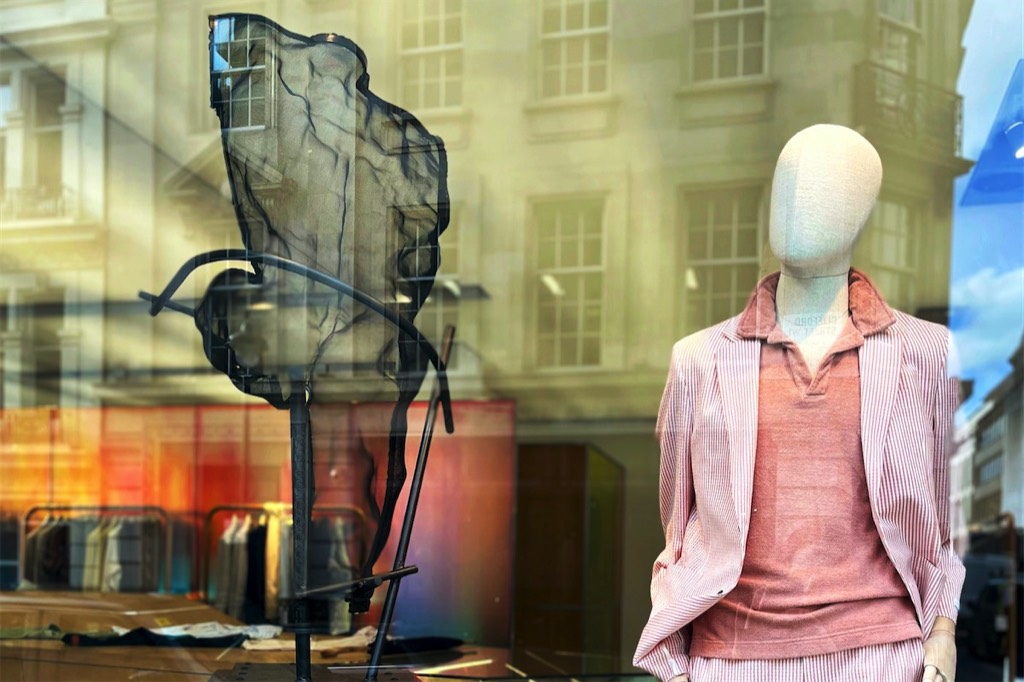 A transparent male figure in a fashion shop window in London, Savile Row