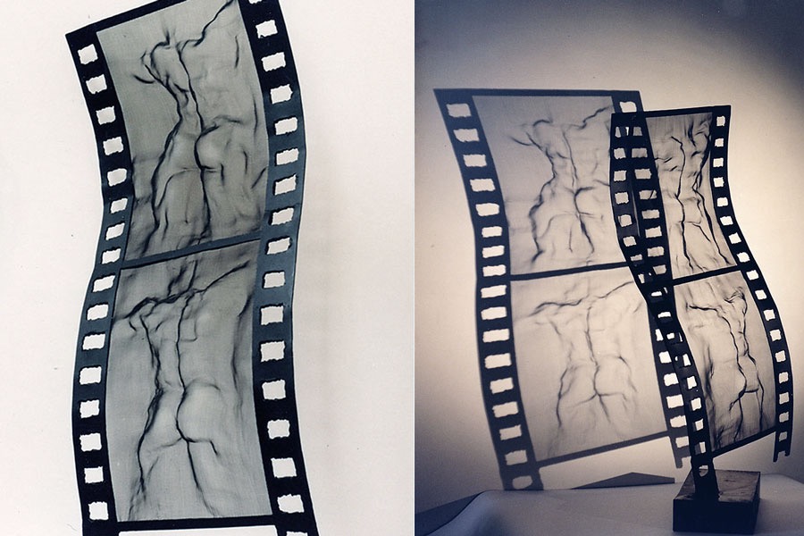 2 views of a large film strip sculpture with semi-transparent insets depicting bodies by David Begbie