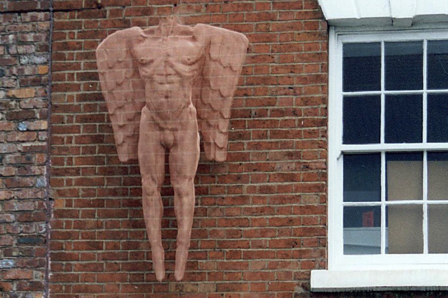 Outdoor sculpture of a male angel figure, wall-mounted on a brick wall in Birmingham Jewellery Quarter