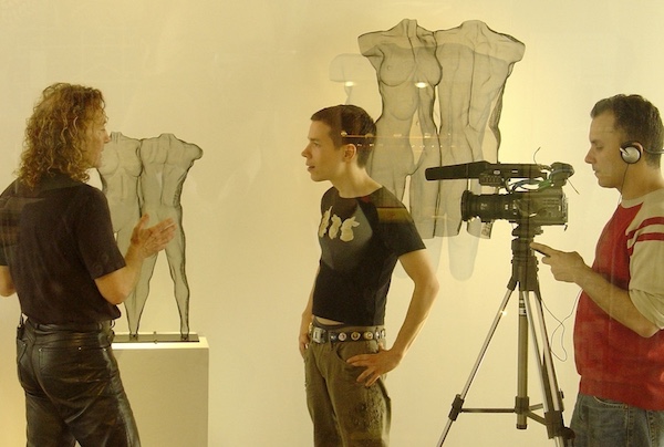 Interviewer asks sculptor in front of his work