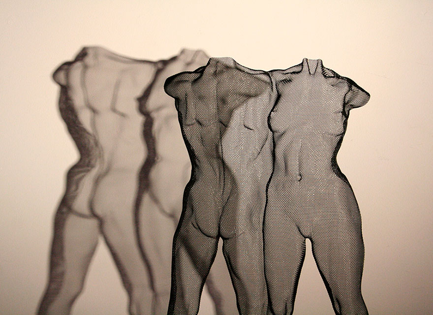 Black modern sculpture of two nude figures made from steel-wire