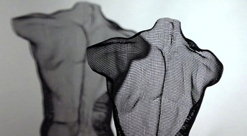 Detail of a male back sculpture by David Begbie, in black colour on grey background